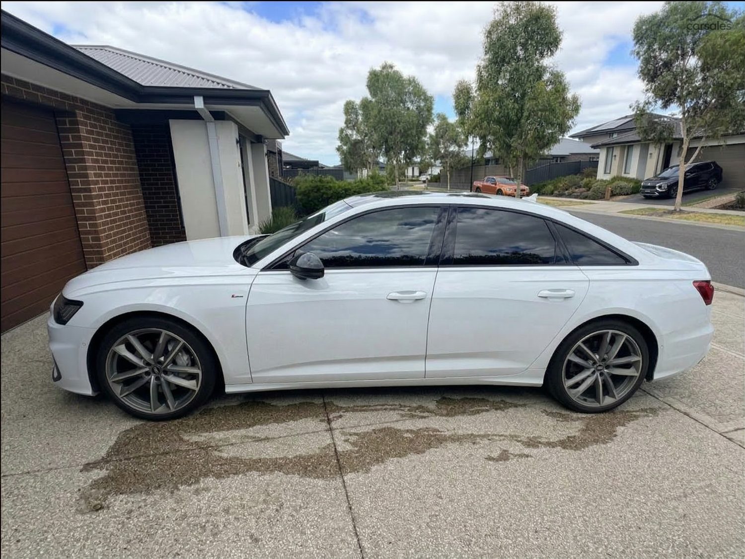 White sedan parked on a residential driveway after a mobile wash